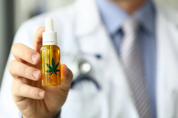 Male doctor hold bottle with marijuana oil — Stock Photo, Image