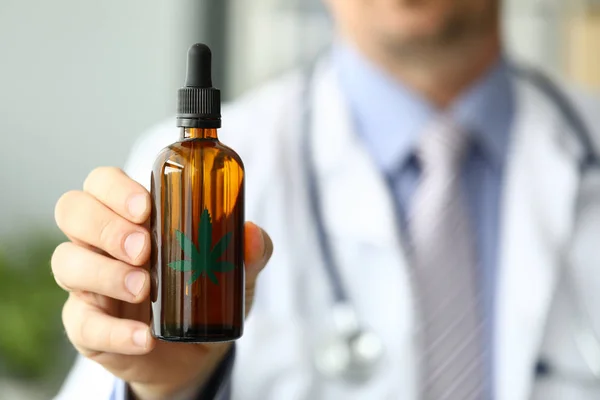 Médico masculino segurar garrafa com óleo de maconha — Fotografia de Stock