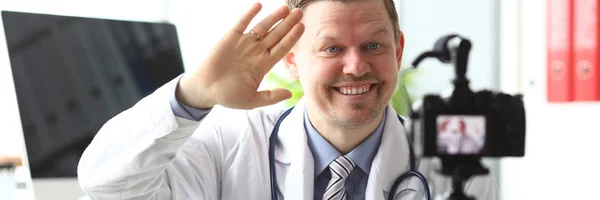 Sorrindo macho milenar médico onda sua — Fotografia de Stock