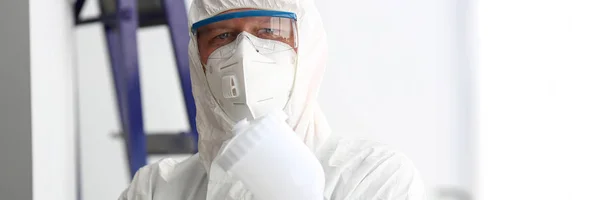 Workman hold in arm airbrush gun wearing protective suit — Stock Photo, Image