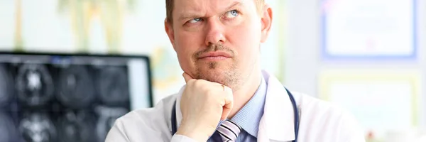 Férfi orvos furcsa arckifejezés ül az irodájában — Stock Fotó