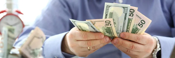 Mannelijke armen tellen grote hoeveelheid Amerikaanse valuta op werktafel — Stockfoto