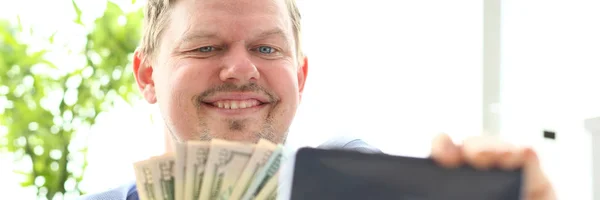 Hombre haciendo auto foto con la cámara del teléfono móvil posando con un montón de dinero —  Fotos de Stock