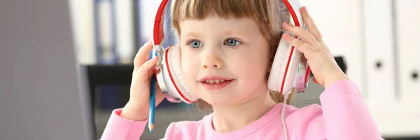 Niña usando auriculares use computadora móvil — Foto de Stock