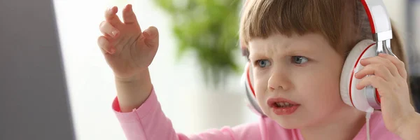 Menina usando fones de ouvido usando computador agressivo articulando — Fotografia de Stock