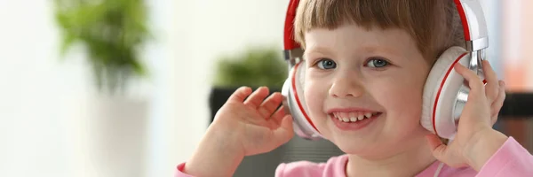 Little girl wearing headphones use mobile computer — Stock Photo, Image