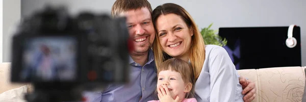 Молода щаслива сім'я сидить на дивані роблячи портрет фотосесії — стокове фото