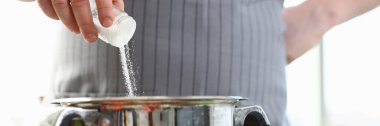 Mutfak şefi tencerede beyaz deniz tuzu ekleme