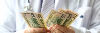 Doktorun erkek eli elinde dolar nakit yarıya
