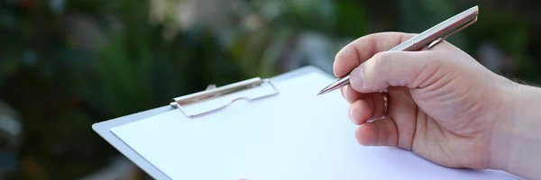 Het menselijke hand schrijven op Klembord met wit document — Stockfoto
