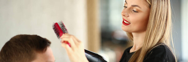 Блондинка парикмахер с помощью расчёски для волос
