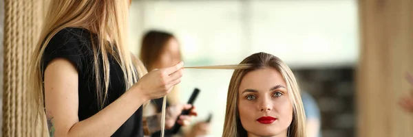 Cabeleireiro segurando longa cadeia de cabelo do cliente — Fotografia de Stock