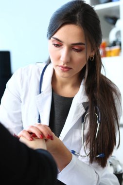 Genç kadın doktor hasta el ile tutar