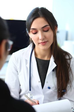 Kadın doktor gülümseyen güzel hasta ile konuşmak