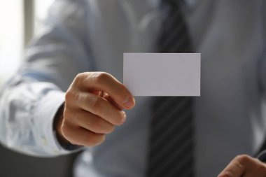 Takım elbiseli erkek kol ziyaretçiye boş arama kartı vermek