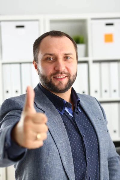 Joven guapo prometedor hombre de negocios trabajo en la oficina mostrar dedo grande hacia arriba — Foto de Stock