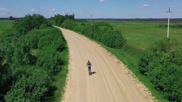 Homme promenades vélo sur la route de campagne sablonneuse — Video