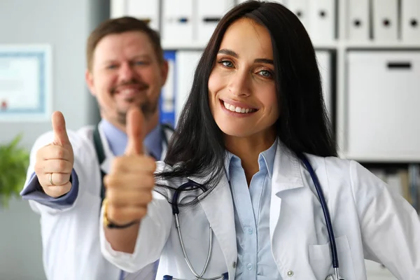 Skupina usmívající se šťastných doktorů ukazující palec — Stock fotografie