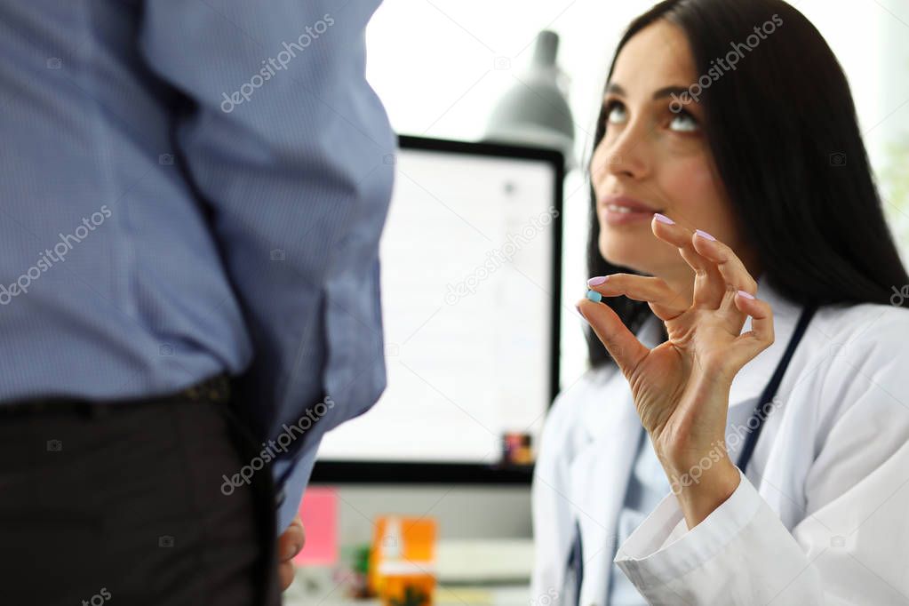 Female GP in hospital office offering to man little blue pill