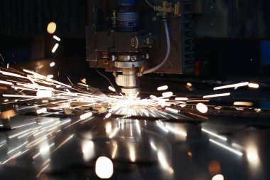 Lazer metall kesme cnc makine. Sinek ateşi arka plana kıvılcım lar.
