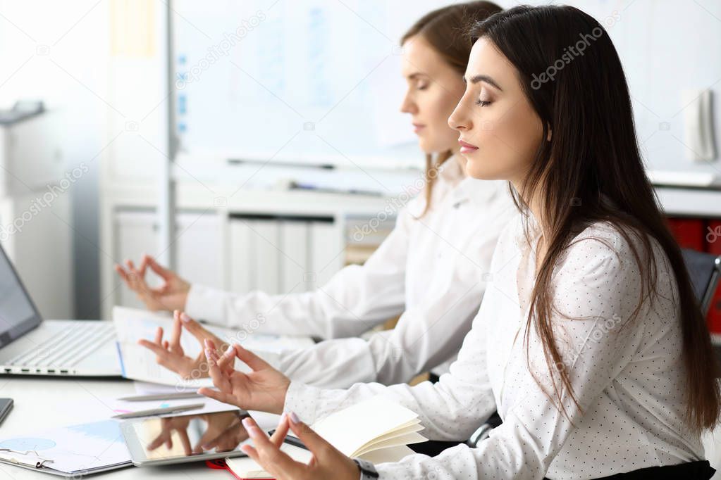 Two businesswoman relaxed in office sit table.