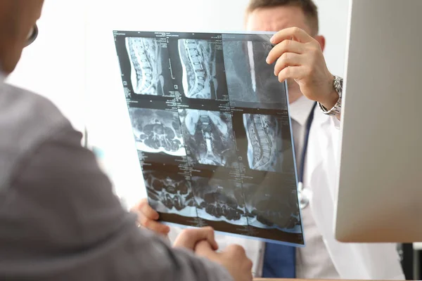 Arzt hält Röntgenbild der Wirbelsäule in der Hand — Stockfoto