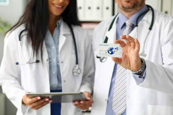 Dos médicos mostrando tarjeta de plástico en la cámara — Foto de Stock