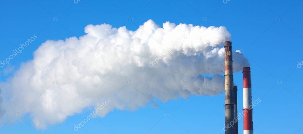 White smoke comes from pipes against blue sky