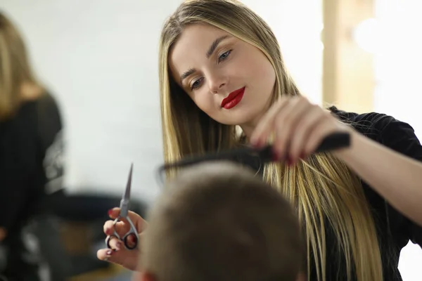 Giovane donna barbiere taglio cliente capelli in salone — Foto Stock