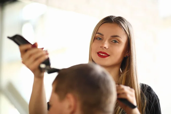 Blondýna kadeřník stříhací strojek elektrickým holicím přístrojem — Stock fotografie