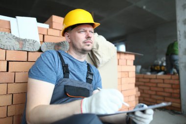 Sert şapkalı düşünceli bir inşaatçı.