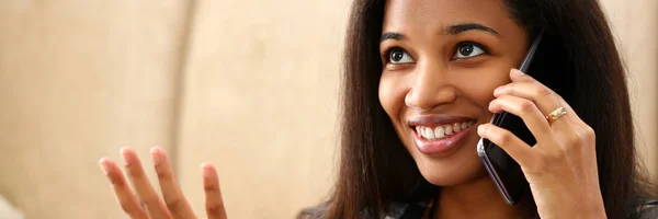Sorrindo mulher negra segurar na mão telefone celular em casa — Fotografia de Stock