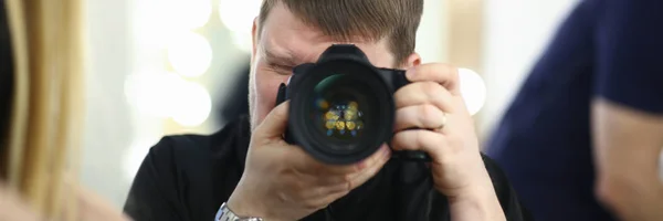 Mężczyzna fotograf trzyma kamerę w — Zdjęcie stockowe