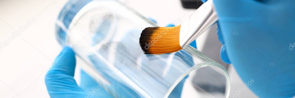 Male hand in blu protective gloves hold brush