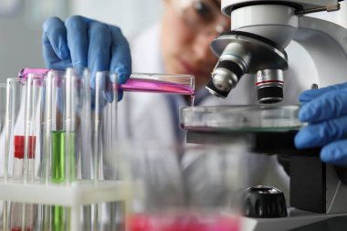 Laboratuvar asistanı inceleme için sıvı doldurur