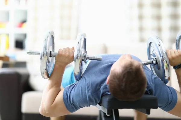 Hombre haciendo ejercicios de fuerza con pesas en casa —  Fotos de Stock