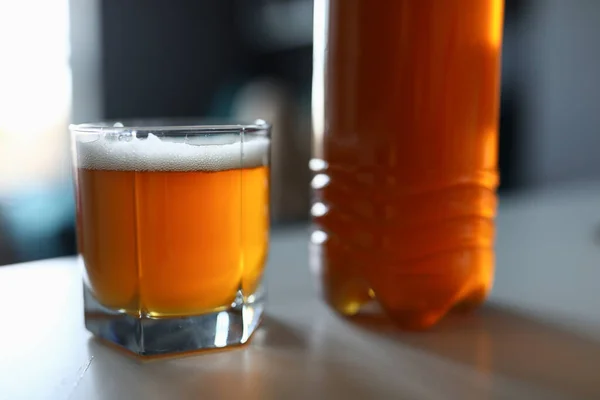 Sul tavolo c'è bottiglia piena e birra fresca di vetro — Foto Stock