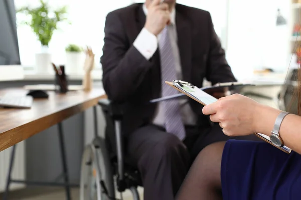 Чоловік бос на інвалідному візку говорить з жіночим офісом — стокове фото