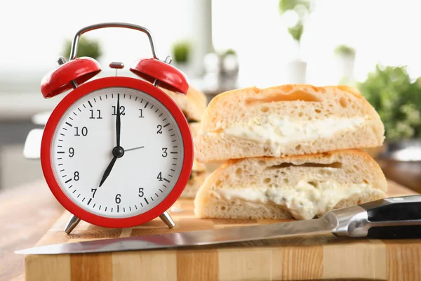Mesa un reloj despertador y desayuno pan y salsa —  Fotos de Stock