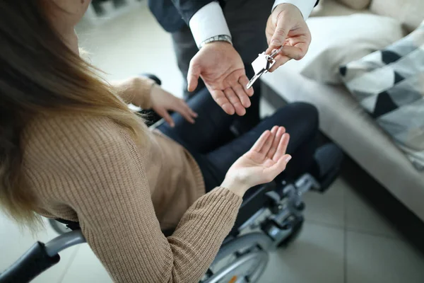 Official gives a girl on wheelchair house keys — Stock Photo, Image