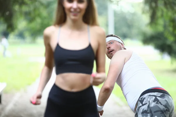 Mężczyzna wstrząśnięty w piękny dziewczyna działa przez park — Zdjęcie stockowe