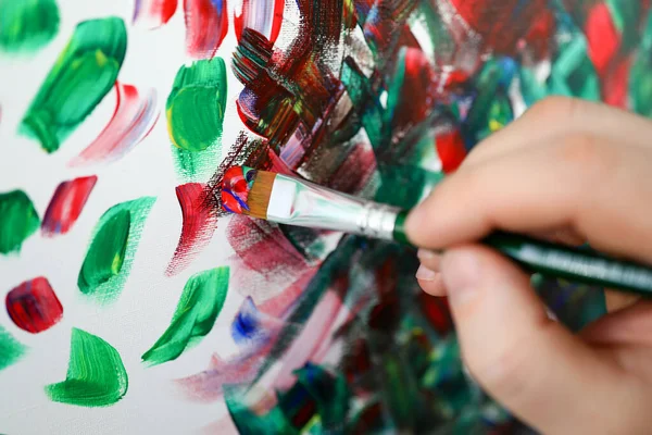 Mãos segurando escova com tinta multi-colorida — Fotografia de Stock