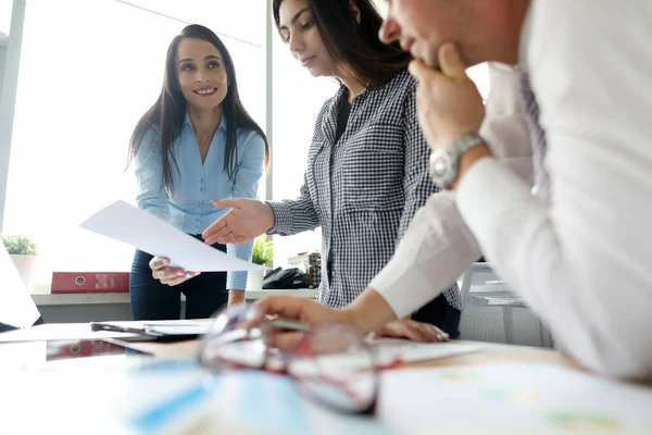 Alegre morena de pelo largo hablando con sus colegas — Foto de Stock