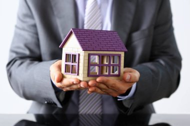 Yaşlı işadamı ev modelini gösteriyor