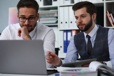 Yakışıklı erkekler dizüstü bilgisayara bakıyor.