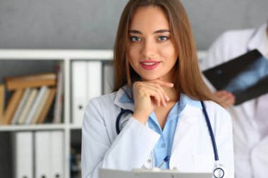 Neşeli genç doktor doğrudan kameraya bakıyor.