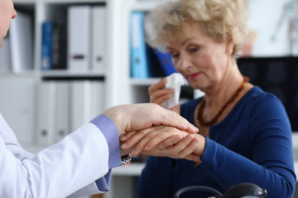 An elderly woman cries at doctors appointment