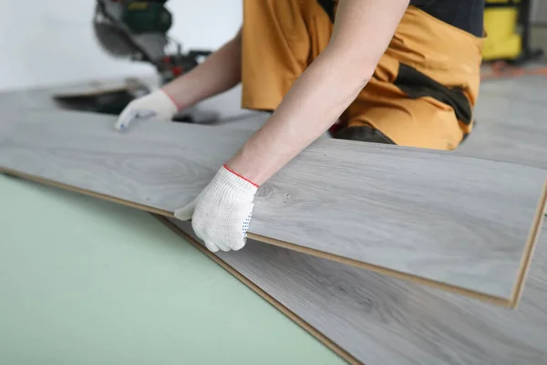 Repairman replaces laminate panels floor apartment