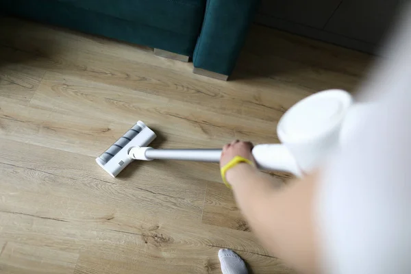 Female hand vacuums floor covering in an apartment — Stock Photo, Image