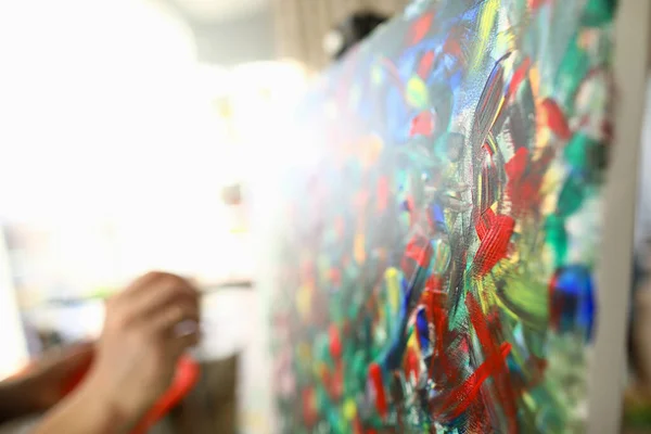 Człowiek maluje duży jasny abstrakcyjny obraz malarski — Zdjęcie stockowe